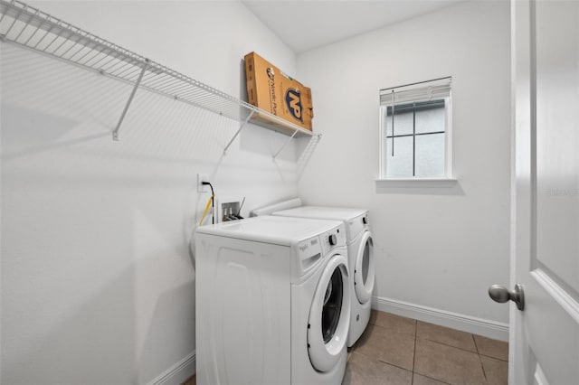 clothes washing area featuring light tile patterned flooring and washing machine and clothes dryer