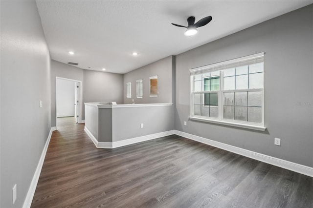 spare room featuring ceiling fan and dark wood-type flooring