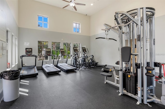 workout area featuring a towering ceiling and ceiling fan