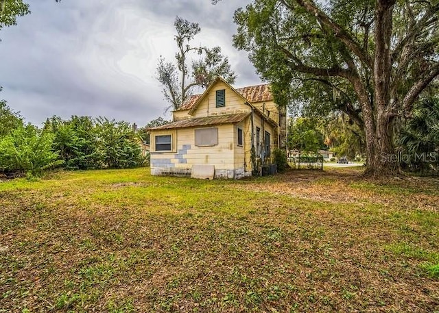 view of side of property featuring a yard and central AC unit