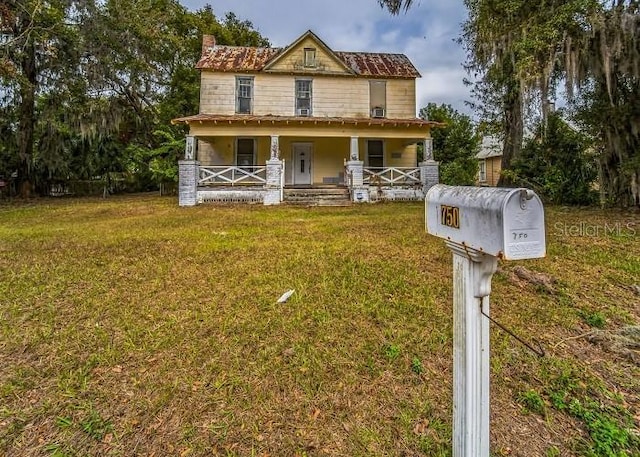 view of front of property with covered porch and a front yard