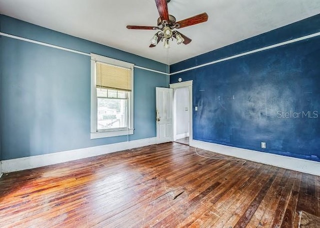 empty room with hardwood / wood-style flooring and ceiling fan