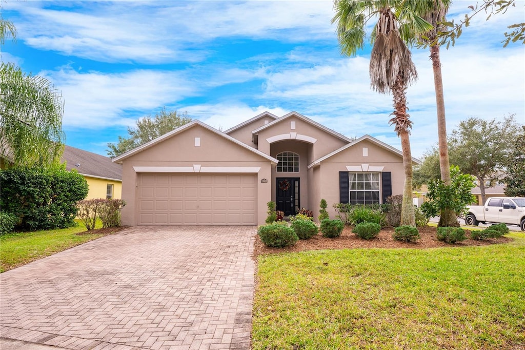 ranch-style home with a front lawn and a garage