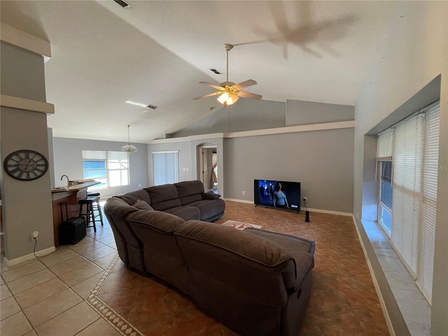 tiled living room with ceiling fan, lofted ceiling, and sink