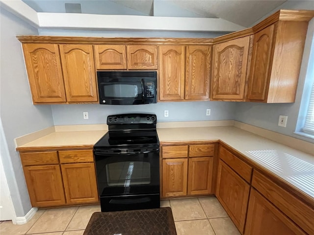 kitchen with light tile patterned floors, black appliances, and lofted ceiling