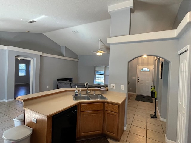 kitchen featuring vaulted ceiling, ceiling fan, sink, light tile patterned floors, and dishwasher