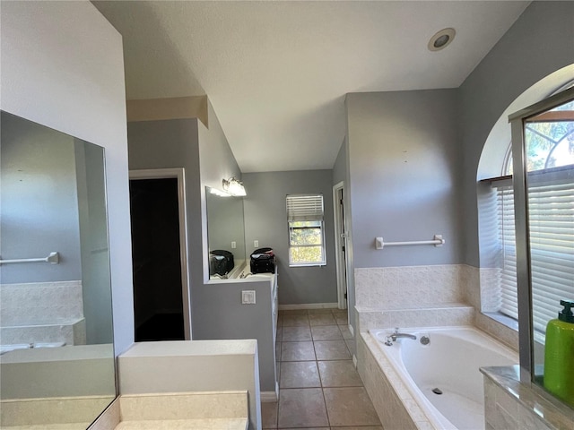 bathroom with vanity, a relaxing tiled tub, tile patterned floors, and plenty of natural light