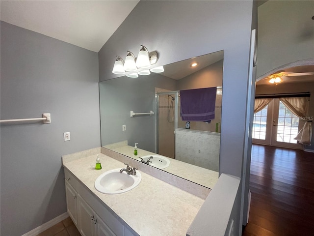 bathroom with french doors, wood-type flooring, vaulted ceiling, vanity, and a shower with shower door