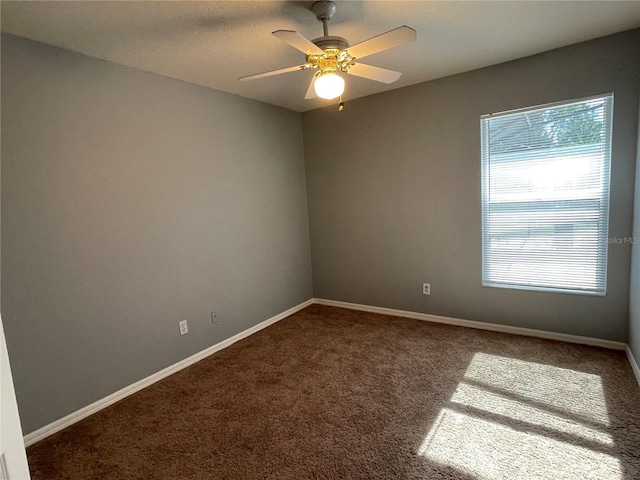 carpeted spare room featuring plenty of natural light and ceiling fan