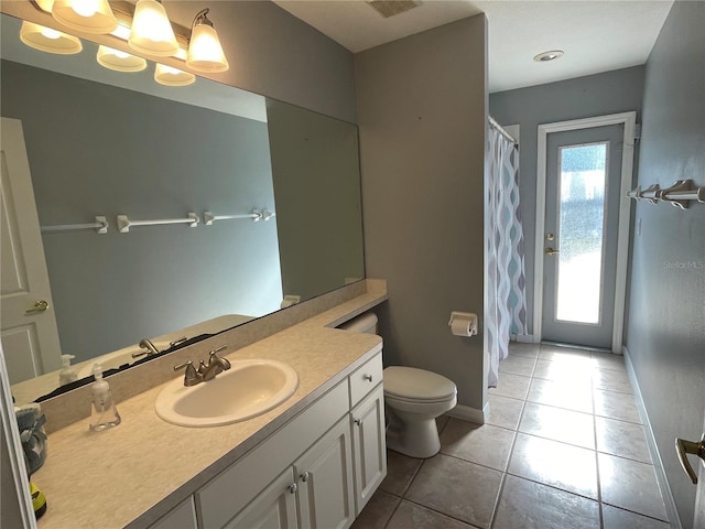 bathroom featuring tile patterned flooring, vanity, and toilet