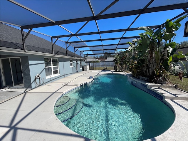 view of pool featuring glass enclosure and a patio area