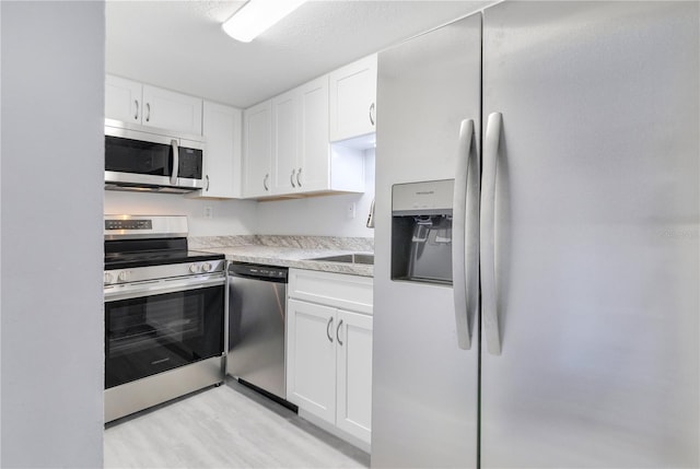 kitchen featuring white cabinets, appliances with stainless steel finishes, and sink