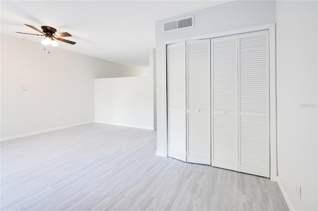 unfurnished bedroom featuring a closet, light hardwood / wood-style flooring, and ceiling fan