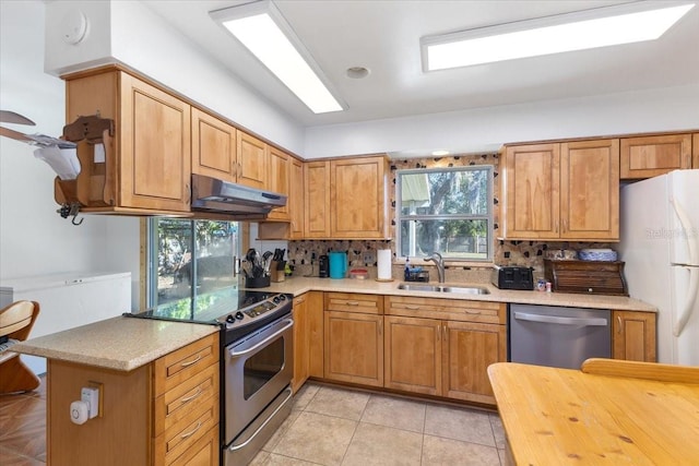 kitchen featuring backsplash, sink, light tile patterned floors, appliances with stainless steel finishes, and kitchen peninsula