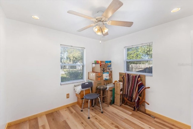 living area with light hardwood / wood-style flooring and ceiling fan