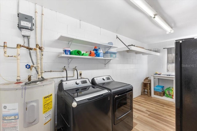 laundry area featuring light hardwood / wood-style floors, independent washer and dryer, and water heater