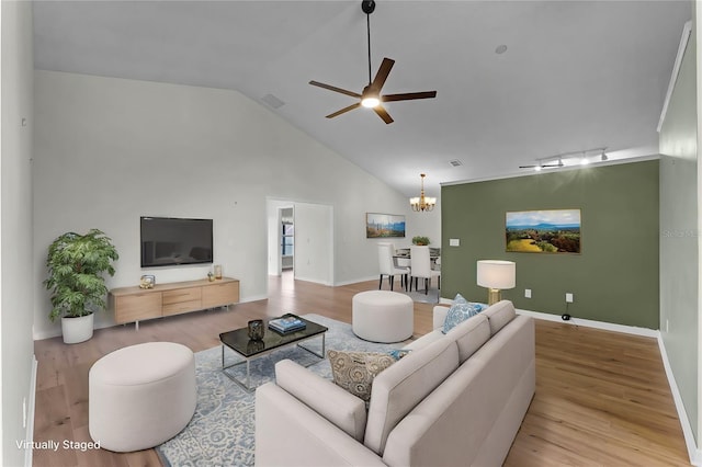 living room featuring ceiling fan with notable chandelier, track lighting, high vaulted ceiling, and light wood-type flooring