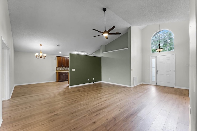 unfurnished living room featuring high vaulted ceiling, ceiling fan with notable chandelier, a textured ceiling, and light wood-type flooring