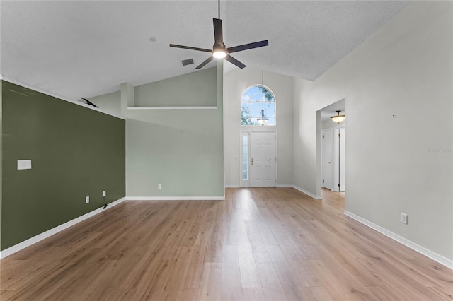 foyer with ceiling fan, light hardwood / wood-style flooring, high vaulted ceiling, and a textured ceiling