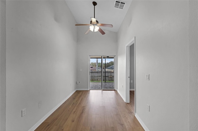 unfurnished room with ceiling fan, high vaulted ceiling, and light hardwood / wood-style flooring