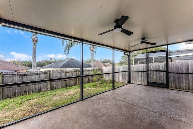 unfurnished sunroom featuring ceiling fan and a healthy amount of sunlight