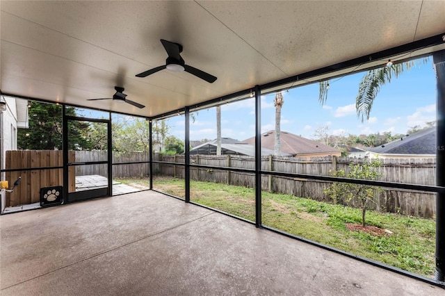 unfurnished sunroom with ceiling fan