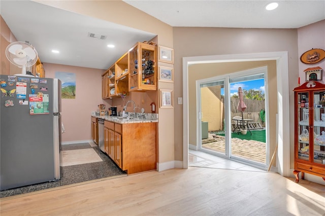 743 Golden Sunshine Cir, Orlando, FL 32807 - kitchen featuring light stone counters, sink, stainless steel appliances, and light hardwood / wood-style flooring