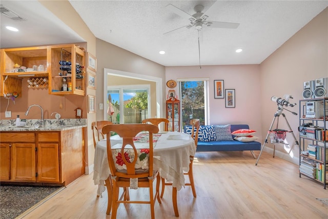 743 Golden Sunshine Cir, Orlando, FL 32807 - dining area with a textured ceiling, light wood-type flooring, ceiling fan, and sink