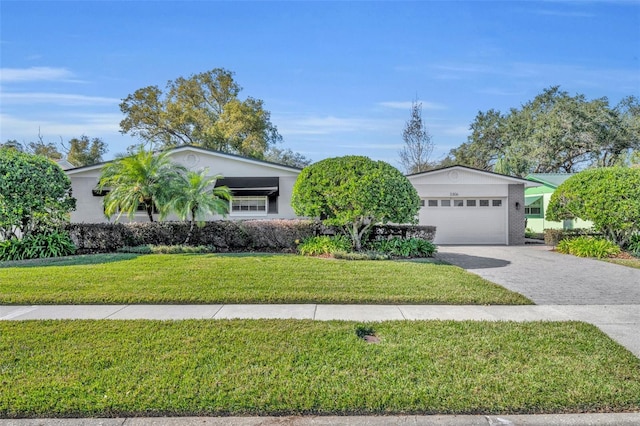 ranch-style home featuring a garage and a front lawn