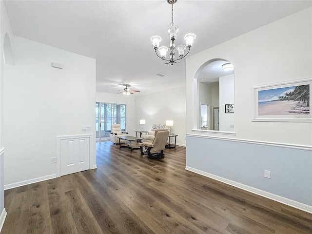 dining space with visible vents, baseboards, a ceiling fan, arched walkways, and dark wood-type flooring