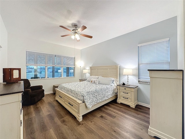 bedroom with a ceiling fan, baseboards, and dark wood-style flooring