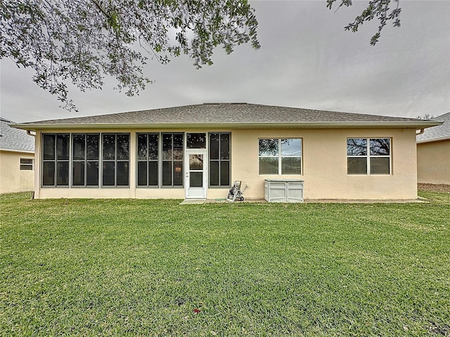 rear view of property with a sunroom, stucco siding, and a yard