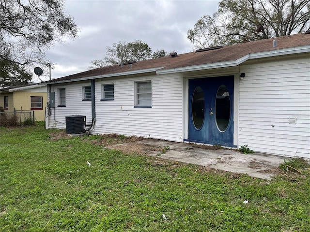 back of property with a yard and central AC unit