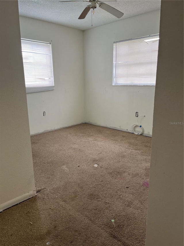 spare room with carpet, a textured ceiling, and ceiling fan