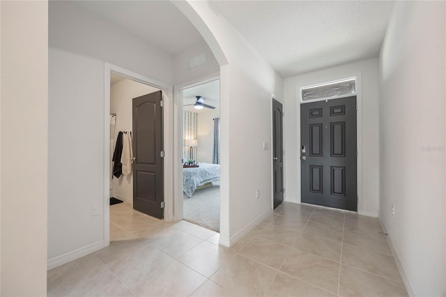 tiled entrance foyer featuring a textured ceiling and ceiling fan