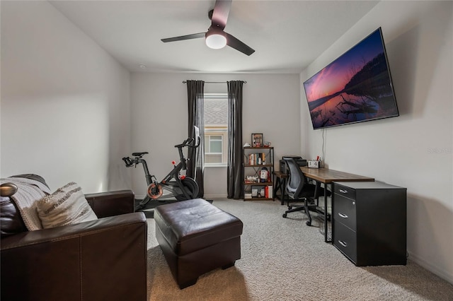 carpeted home office featuring ceiling fan