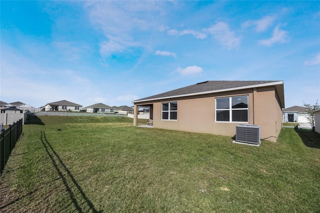 back of property with a lawn and cooling unit