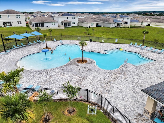 view of swimming pool with pool water feature and a lawn