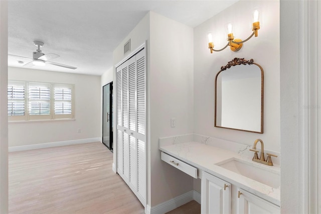 bathroom with ceiling fan, vanity, and wood-type flooring