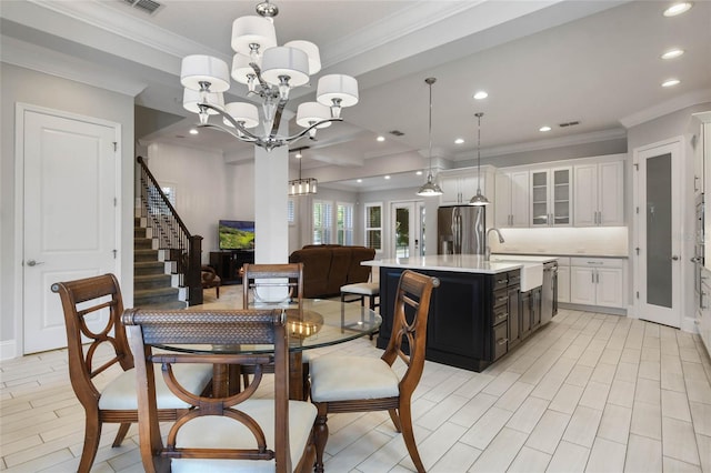 dining space featuring an inviting chandelier, ornamental molding, and sink