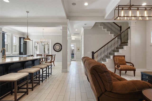 living room featuring ornate columns, crown molding, and light wood-type flooring