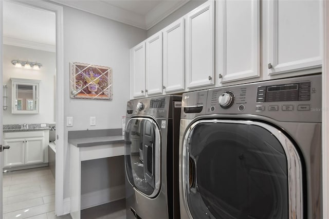 washroom featuring cabinets, crown molding, washer and dryer, and sink