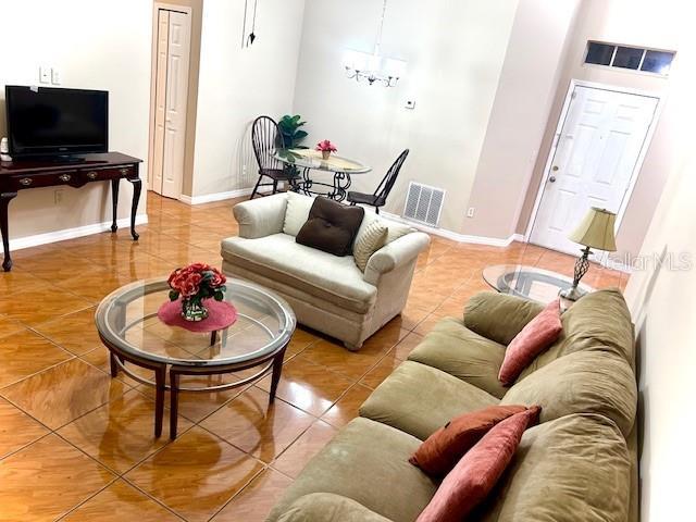 tiled living room featuring a chandelier