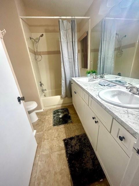 full bathroom with tile patterned floors, vanity, toilet, and shower / bath combo with shower curtain