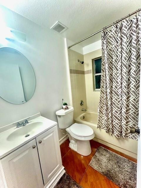 full bathroom featuring hardwood / wood-style floors, vanity, toilet, shower / bathtub combination with curtain, and a textured ceiling