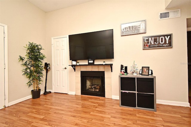 living room with light wood-type flooring and a fireplace