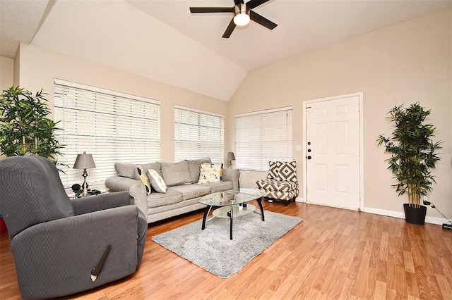 living room featuring hardwood / wood-style flooring, ceiling fan, and vaulted ceiling