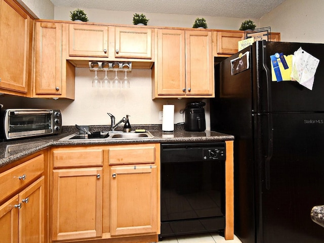 kitchen with sink, light tile patterned floors, black appliances, and a textured ceiling