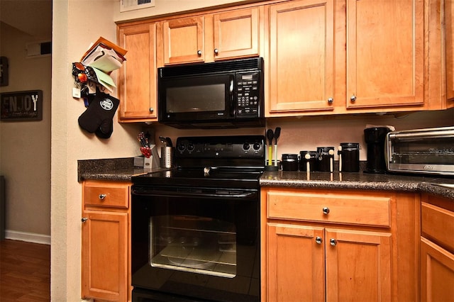 kitchen with dark hardwood / wood-style flooring and black appliances