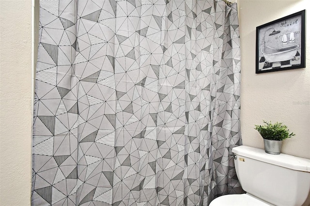 bathroom featuring curtained shower and toilet